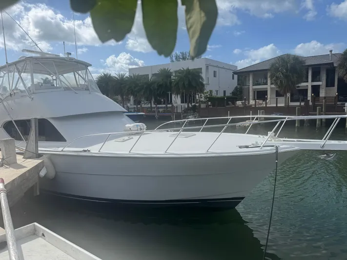 Audrey IV Yacht Photos Pics 2002 Hatteras 50 Convertible yacht docked in a sunny marina setting.