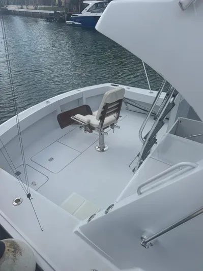 Audrey IV Yacht Photos Pics 2002 Hatteras 50 Convertible yacht deck with fishing chair, docked by the water.