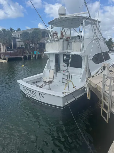 Audrey IV Yacht Photos Pics 2002 Hatteras 50 Convertible yacht docked in a marina, clear sky background.