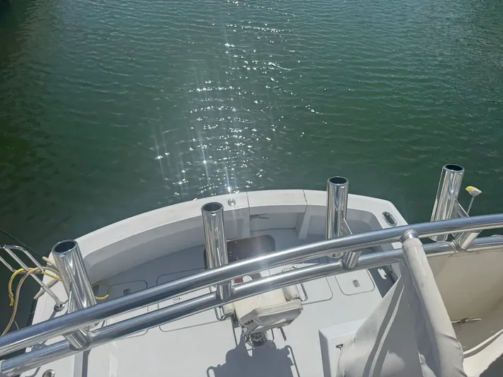 Audrey IV Yacht Photos Pics 2002 Hatteras 50 Convertible yacht deck with rod holders, overlooking calm water.
