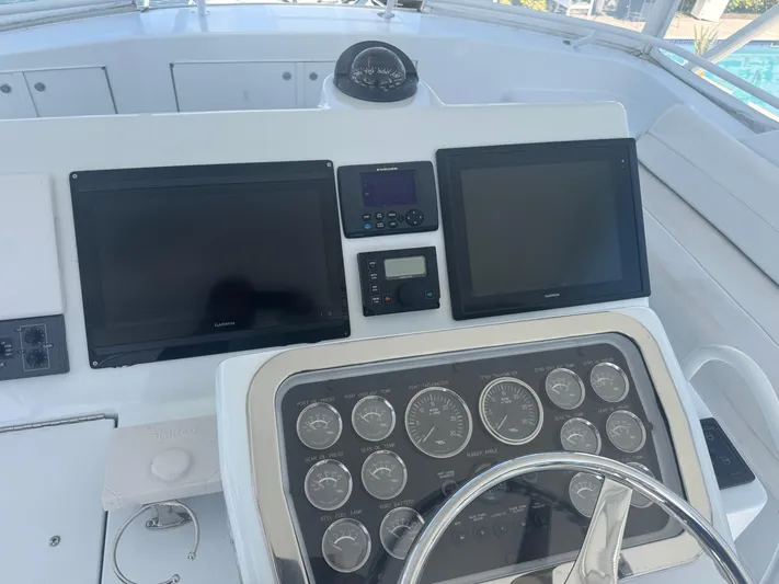 Audrey IV Yacht Photos Pics Control panel of a 2002 Hatteras 50 Convertible yacht with navigation screens and gauges.