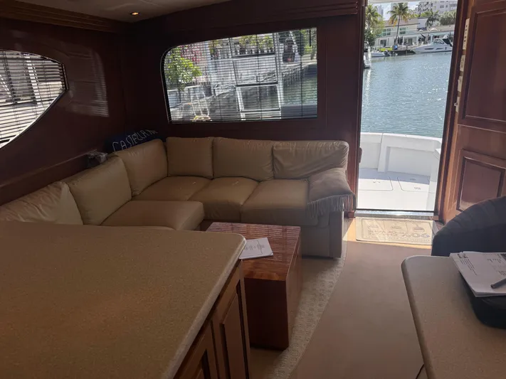 Audrey IV Yacht Photos Pics Interior of 2002 Hatteras 50 Convertible yacht with beige seating and waterfront view.