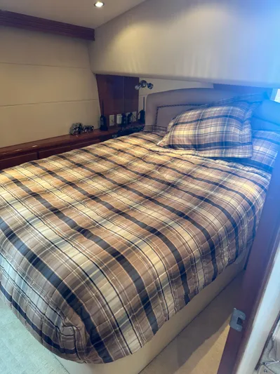 Audrey IV Yacht Photos Pics Cozy bedroom in 2002 Hatteras 50 Convertible yacht with plaid bedding.