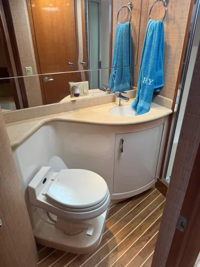 Audrey IV Yacht Photos Pics Bathroom interior of 2002 Hatteras 50 Convertible yacht with modern fixtures and wooden flooring.