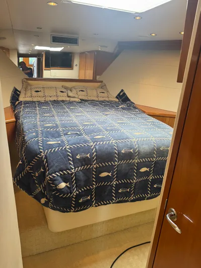 Audrey IV Yacht Photos Pics 2002 Hatteras 50 Convertible cabin with a cozy bed and nautical-themed bedding.