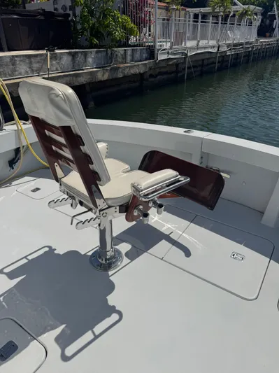 Audrey IV Yacht Photos Pics 2002 Hatteras 50 Convertible fishing chair on deck by the water.