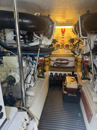 Audrey IV Yacht Photos Pics Engine room of a 2002 Hatteras 50 Convertible yacht, showcasing dual engines and equipment.