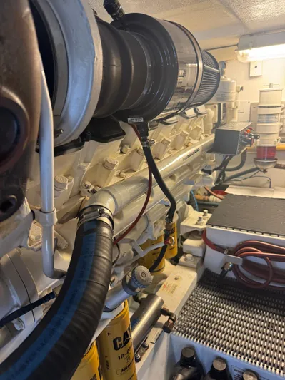 Audrey IV Yacht Photos Pics Engine room of 2002 Hatteras 50 Convertible yacht, showcasing mechanical components and hoses.