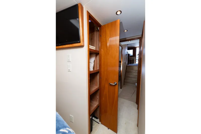 Audrey IV Yacht Photos Pics Interior hallway of 2002 Hatteras 50 Convertible yacht with wooden door and shelving.