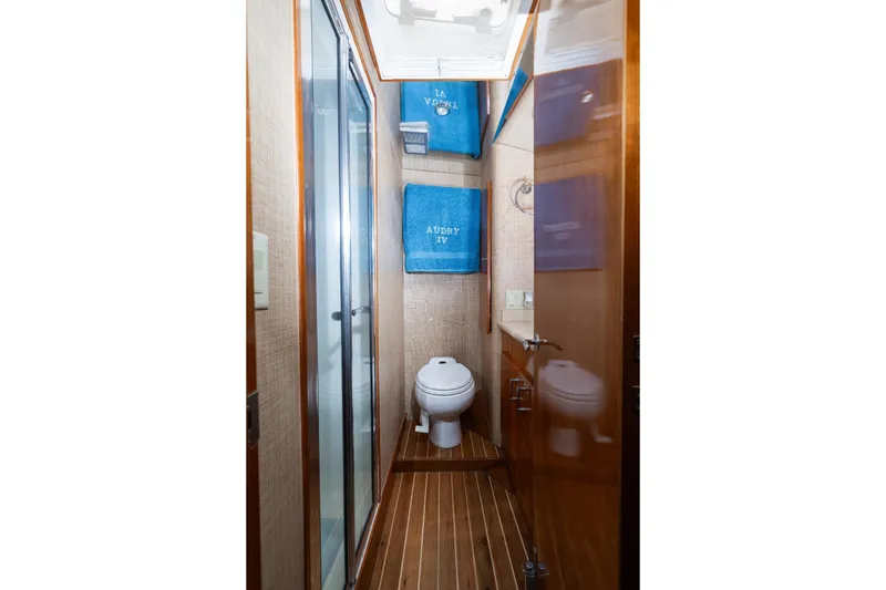 Audrey IV Yacht Photos Pics Bathroom interior of 2002 Hatteras 50 Convertible yacht with wooden flooring and blue towels.