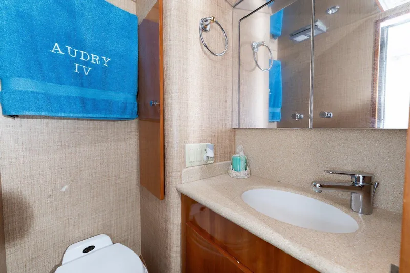 Audrey IV Yacht Photos Pics Bathroom interior of 2002 Hatteras 50 Convertible yacht with blue towel and modern fixtures.