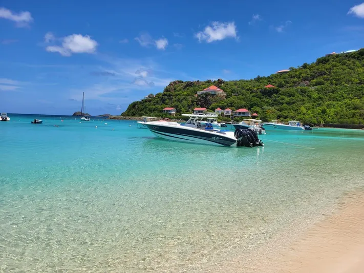  Yacht Photos Pics A 2011 Motion Marine 42 boat anchored in clear turquoise waters near a tropical island.