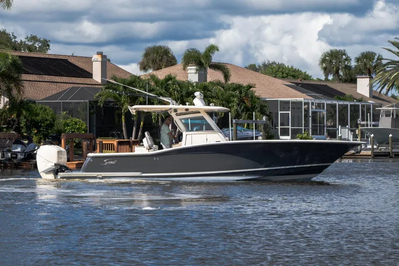  Yacht Photos Pics 2019 Scout 320 LXF boat cruising on a scenic waterway near waterfront homes.
