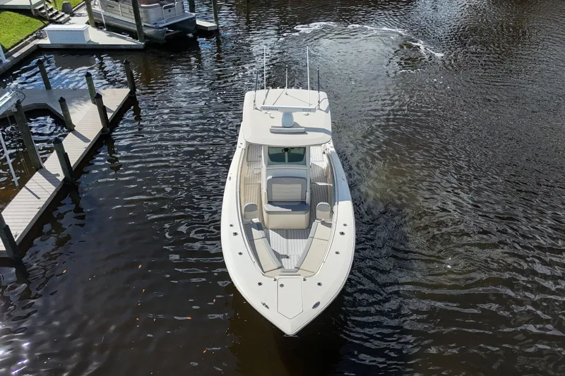  Yacht Photos Pics 2019 Scout 320 LXF boat navigating a calm waterway near docks.