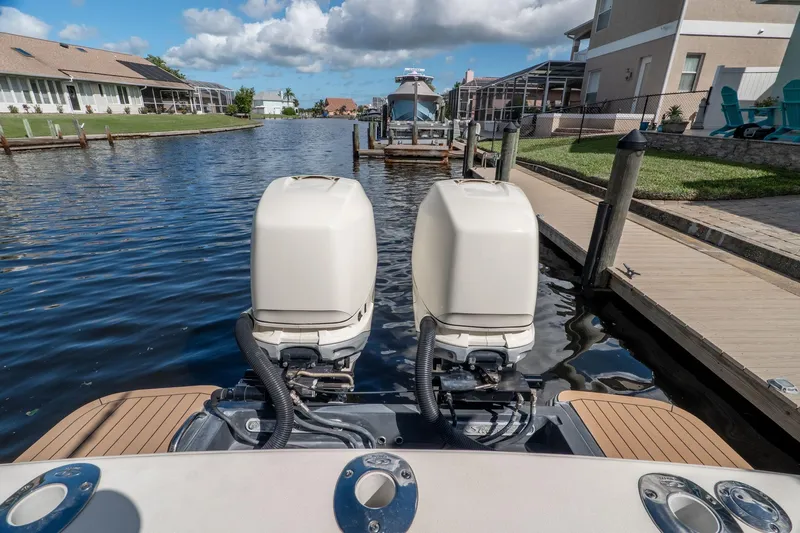  Yacht Photos Pics 2019 Scout 320 LXF boat with dual outboard engines docked in a canal.