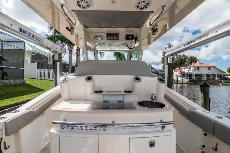  Yacht Photos Pics 2019 Scout 320 LXF boat interior with sink and seating, docked by waterfront homes.