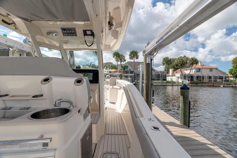  Yacht Photos Pics 2019 Scout 320 LXF boat interior with sink, docked by waterfront homes.