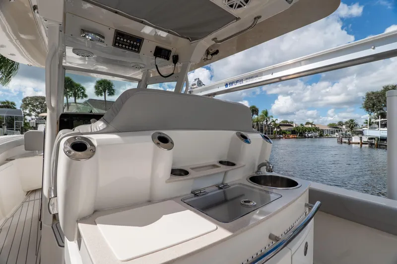  Yacht Photos Pics 2019 Scout 320 LXF boat interior with sink and storage, docked by waterfront homes.
