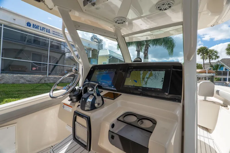  Yacht Photos Pics 2019 Scout 320 LXF boat cockpit with navigation screens and steering wheel.