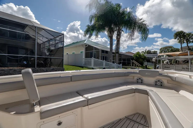  Yacht Photos Pics 2019 Scout 320 LXF boat interior with seating, docked near palm trees and houses.