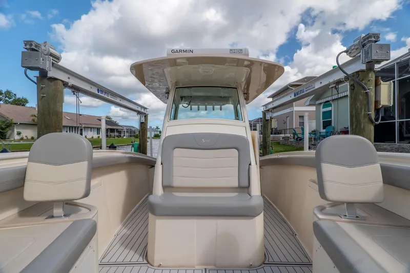  Yacht Photos Pics 2019 Scout 320 LXF boat interior with seating, docked under a blue sky.