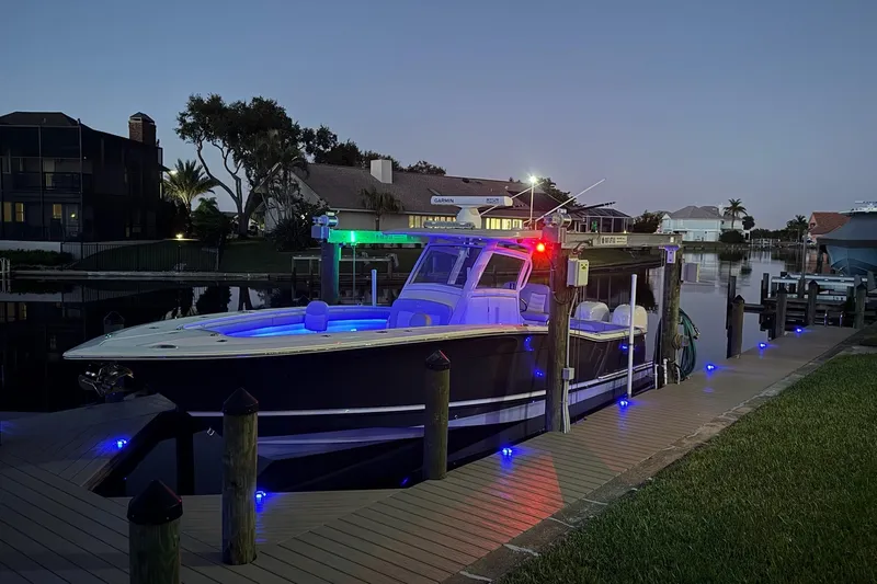  Yacht Photos Pics 2019 Scout 320 LXF boat docked at night with vibrant LED lights.
