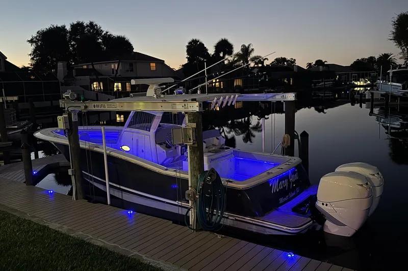  Yacht Photos Pics 2019 Scout 320 LXF boat docked at sunset with blue interior lights.