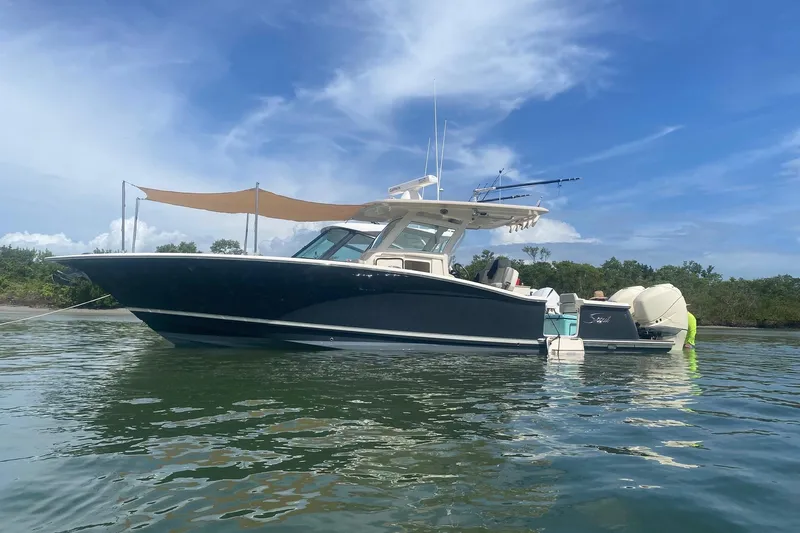  Yacht Photos Pics 2019 Scout 320 LXF boat anchored on calm water under a clear blue sky.