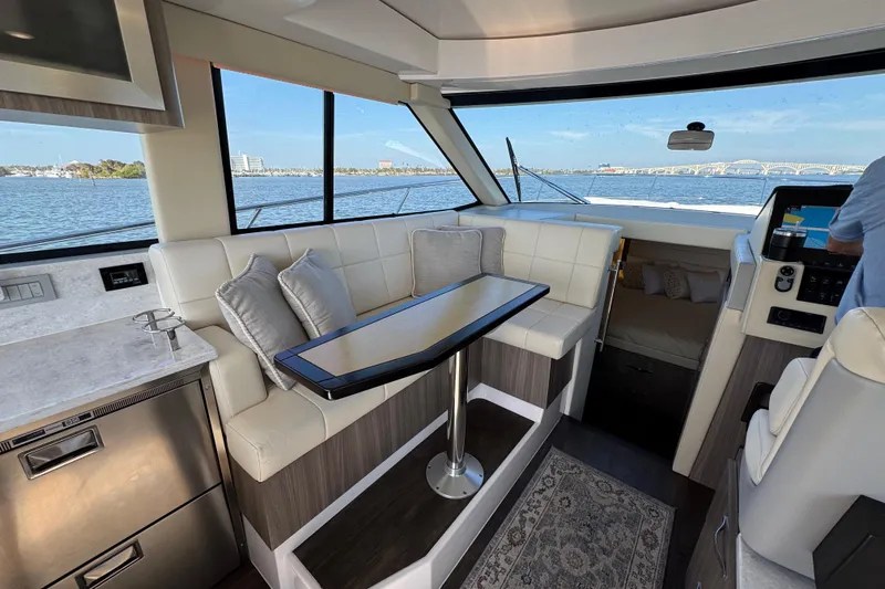 Irresistible Yacht Photos Pics Interior of 2021 Regal 38 XO yacht with seating, table, and scenic water view.