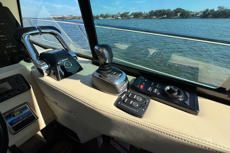 Irresistible Yacht Photos Pics Control panel of 2021 Regal 38 XO yacht with water view through window.