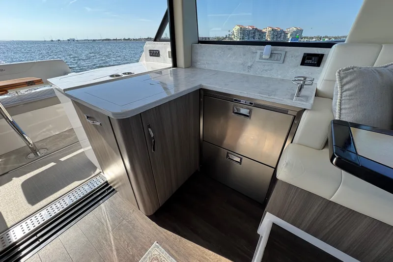 Irresistible Yacht Photos Pics Luxurious interior of 2021 Regal 38 XO yacht with modern kitchenette and waterfront view.