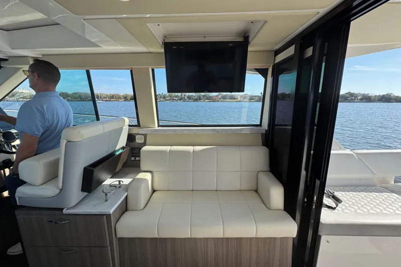 Irresistible Yacht Photos Pics Interior of 2021 Regal 38 XO yacht with seating and water view.