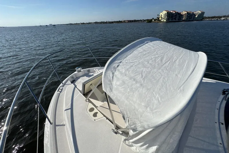 Irresistible Yacht Photos Pics 2021 Regal 38 XO yacht bow with sunshade on calm water.