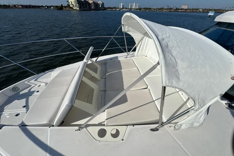 Irresistible Yacht Photos Pics 2021 Regal 38 XO boat with sunshade and cushioned seating on deck.