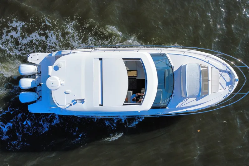 Irresistible Yacht Photos Pics Aerial view of 2021 Regal 38 XO yacht cruising on water.