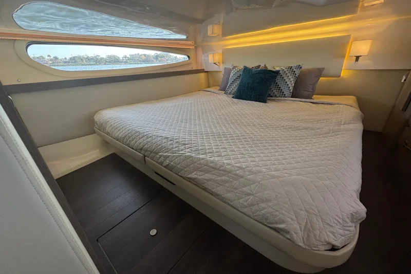 Irresistible Yacht Photos Pics Luxurious bedroom interior of 2021 Regal 38 XO yacht with elegant bedding and ambient lighting.