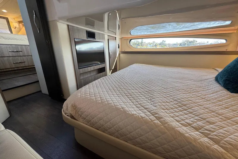 Irresistible Yacht Photos Pics Interior of 2021 Regal 38 XO yacht bedroom with bed, TV, and window view.