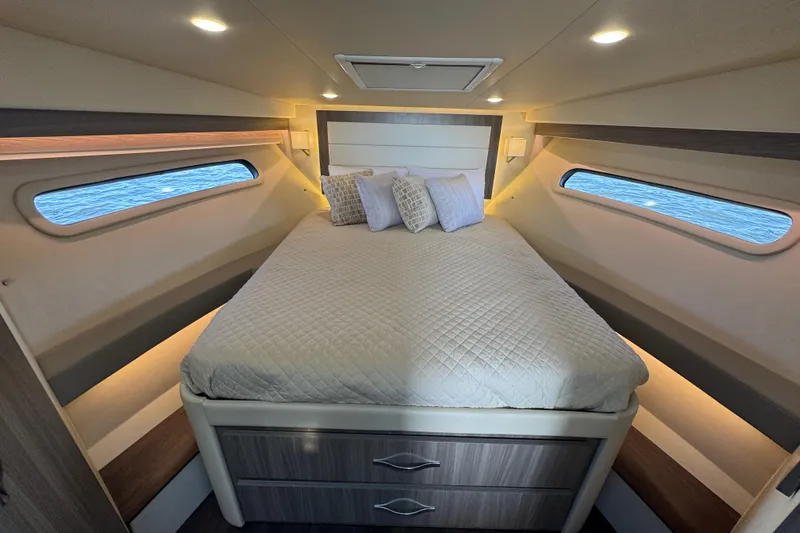 Irresistible Yacht Photos Pics Luxurious cabin interior of 2021 Regal 38 XO yacht with cozy bed and ambient lighting.
