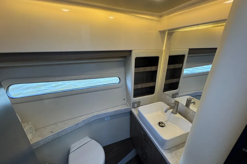 Irresistible Yacht Photos Pics 2021 Regal 38 XO yacht bathroom with modern sink, toilet, and window view.
