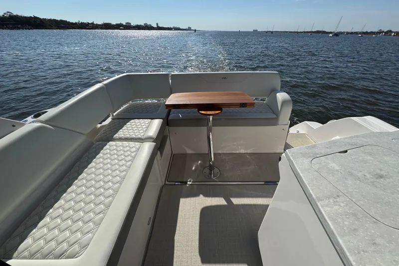 Irresistible Yacht Photos Pics Luxurious seating area on a 2021 Regal 38 XO yacht, overlooking serene waters.
