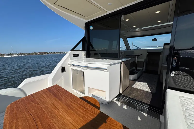 Irresistible Yacht Photos Pics 2021 Regal 38 XO yacht interior with open deck and seating area on the water.