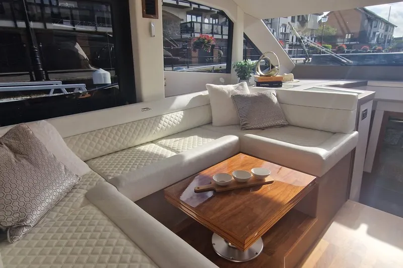 Alouise Yacht Photos Pics Luxurious interior of 2022 Galeon 460 Fly yacht with elegant seating and wooden table.