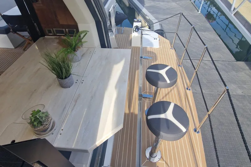 Alouise Yacht Photos Pics Luxurious 2022 Galeon 460 Fly yacht deck with bar stools and potted plants.