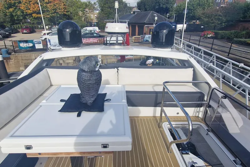 Alouise Yacht Photos Pics 2022 Galeon 460 Fly yacht deck with owl statue, docked in a marina.