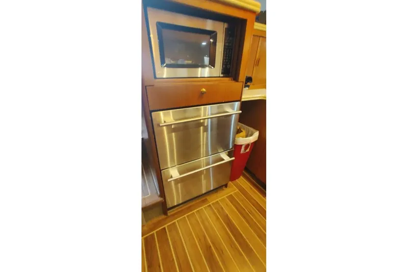  Yacht Photos Pics 1999 Ocean Yachts 48 Express kitchen with stainless steel appliances and wooden cabinetry.