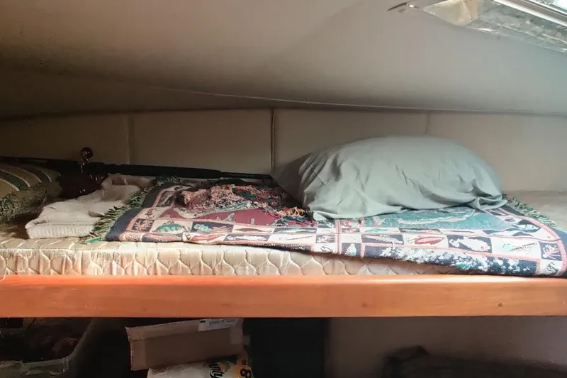  Yacht Photos Pics Cozy cabin bed in 1999 Ocean Yachts 48 Express, featuring colorful blanket and pillow.