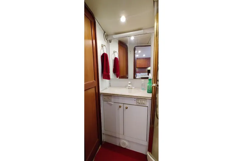  Yacht Photos Pics Bathroom interior of 1999 Ocean Yachts 48 Express with red towels and white cabinetry.