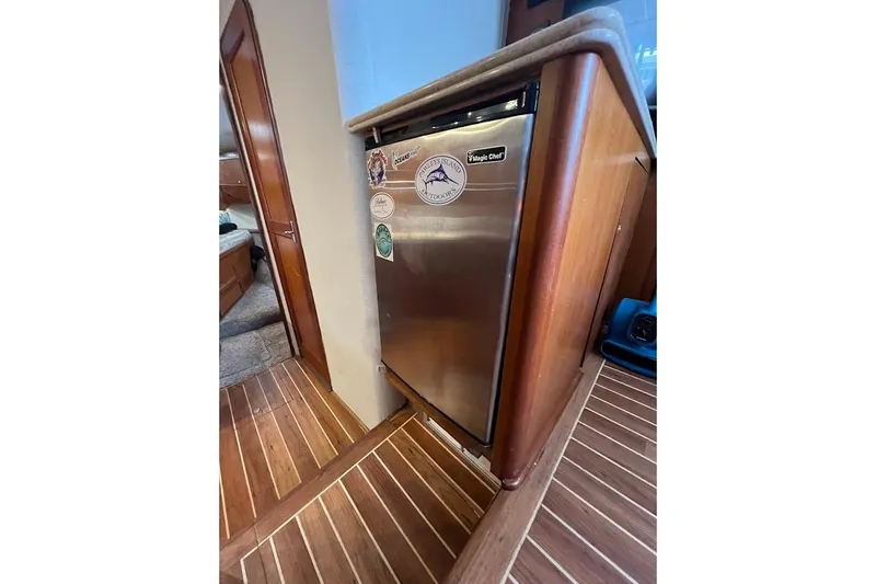  Yacht Photos Pics 1999 Ocean Yachts 48 Express interior with stainless steel fridge and wooden flooring.