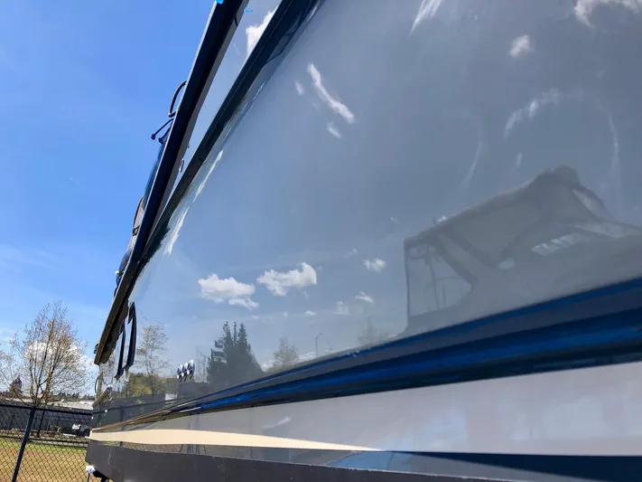  Yacht Photos Pics 2020 Ranger Tugs R-29 boat exterior reflecting blue sky and clouds.