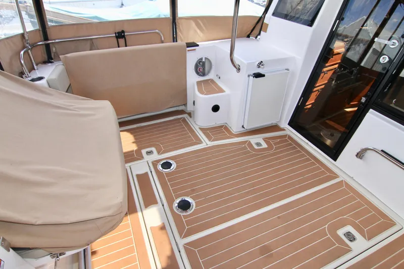  Yacht Photos Pics 2020 Ranger Tugs R-29 boat interior with teak flooring and beige seating.